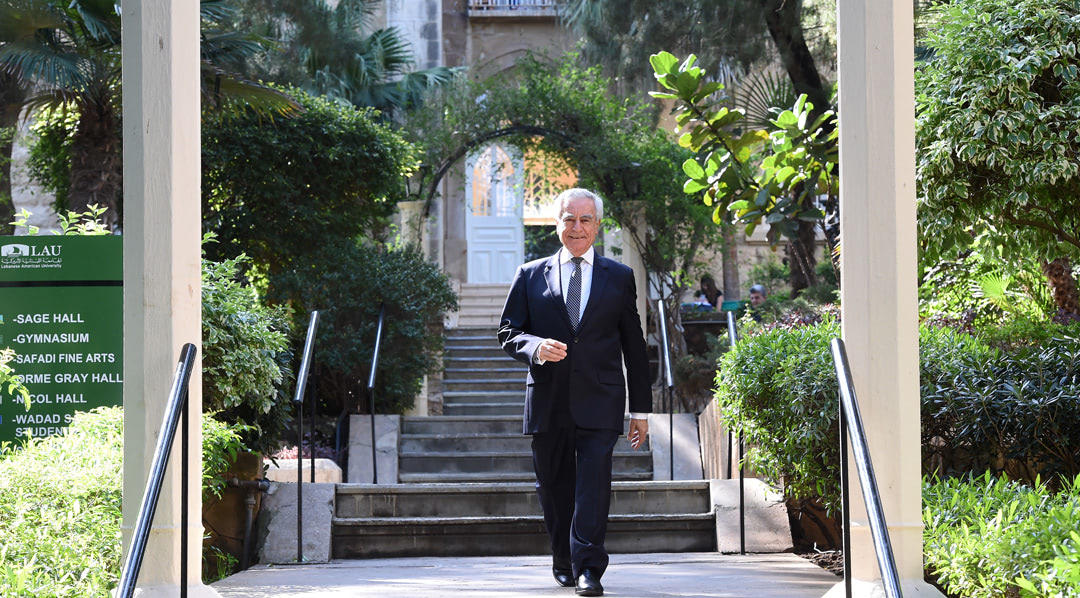 Dr. Joseph Jabbra walking down the Sage Hall stairs